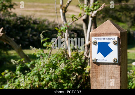 Ein Zeichen auf einem hölzernen Pfosten zeigt ein Pfeil, der auf eine zulässige Reitweg. Stockfoto