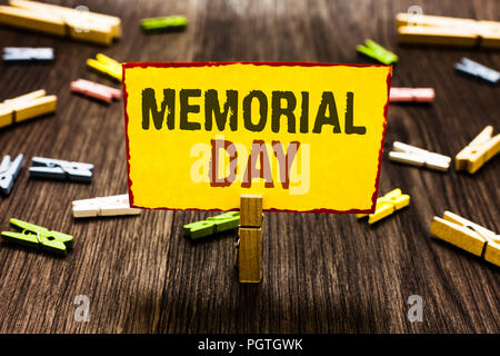 Handschrift Text schreiben Memorial Day. Konzept Sinn zu ehren und die Erinnerung an die Verstorbenen in den militärischen Dienst Clothespin Holding gelbes Papier nicht Stockfoto