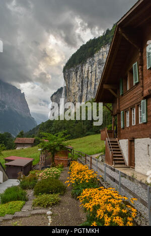 Idyllischen Blick auf Holz- bergbauernhof Häuser in den Schweizer Alpen, Wasserfall im Hintergrund Stockfoto