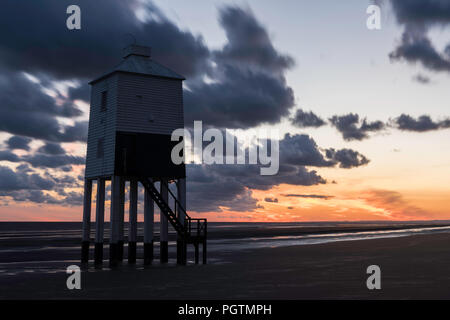 Sonnenuntergang hinter dem Burnham on Sea Leuchtturm bei Ebbe mit Reflexionen in den nassen Sand, Somerset, England Stockfoto