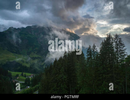 Nebel bei Sonnenuntergang über der Stadt Schrocken Schrocken im Tal in der Region Vorarlberg in Österreich Stockfoto