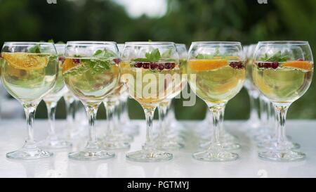 Drei bunte Cocktails in großen Weingläser in einem klassischen Bar Umwelt mit Dutzenden von blurry Alkoholflaschen im Hintergrund. Cocktails cockt Stockfoto