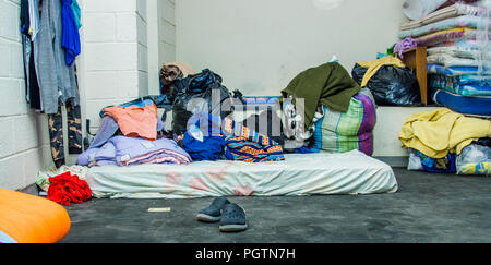 QUITO, Ecuador, 21. AUGUST 2018: Haufen bunte Kleidung, Taschen und Accessoires im Boden von einem Zimmer in ein Refugium für Menschen, die esca Stockfoto