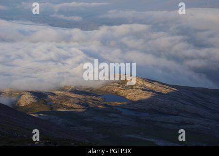 Cloud Inversion Driften über robuste Meall ein 'Ghiubhais Berglandschaft und Lochan. Kinlochewe, Torridon, Schottland, Großbritannien. Juni, 2018. Stockfoto