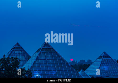 Sun steigt durch Rauch Himmel, Muttart Conservatory Pyramiden, Edmonton, Alberta, Kanada. Stockfoto