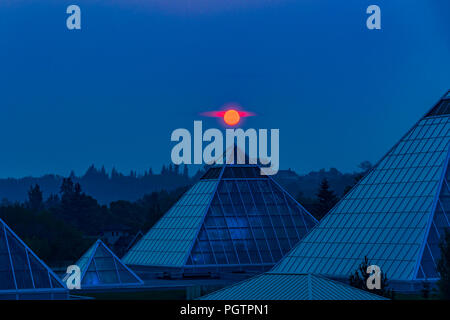 Sun steigt durch Rauch Himmel, Muttart Conservatory Pyramiden, Edmonton, Alberta, Kanada. Stockfoto