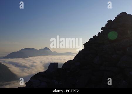 Gipfel Cairn Silhouette auf meall ein 'Ghiubhais, Kinlochewe, Torridon, Schottland. An einem schönen Sommer Abend. Stockfoto