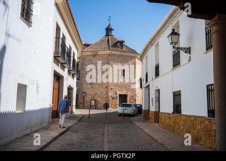 Tembleque, Spanien, ist ein kleines Dorf mit einer Kirche und einem Uhrenturm im Zentrum, das an einem Sommertag ohne Wolken am Himmel fotografiert wurde. Stockfoto