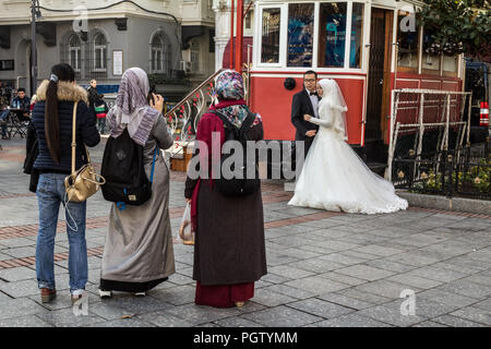 ISTANBUL, Türkei - 27 Dezember, 2015: Die Menschen tragen islamische Schal, Hochzeit Bilder mit Smartphones eines neu verheiratete Paare, die Braut weari Stockfoto