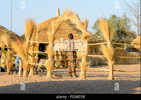 FERLO WÜSTE, SENEGAL - Apr 25, 2017: Unbekannter Fulani Mann in heller Kleidung steht vor der Hütte. Fulanis (peul) sind die größten Stamm in Stockfoto