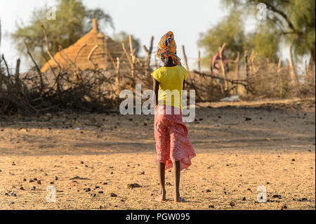 FERLO WÜSTE, SENEGAL - Apr 25, 2017: Unbekannter Fulani Frau im Kopftuch Spaziergänge entlang der Straße von hinten. Fulanis (peul) sind die größten Stamm Stockfoto