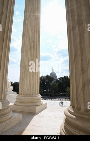 Spalten der U.S. Supreme Court Gebäude mit dem US Capitol im Hintergrund. Stockfoto