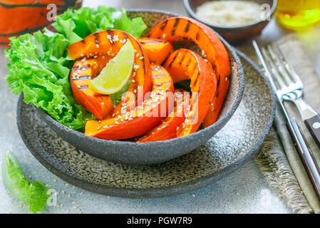 Köstliche leichte Salat mit gegrilltem Kürbis Schichten und Kopfsalat mit Sesam, Zitronensaft und Olivenöl. Gesunde Ernährung, Vegetarische Snack. Selektive fo Stockfoto