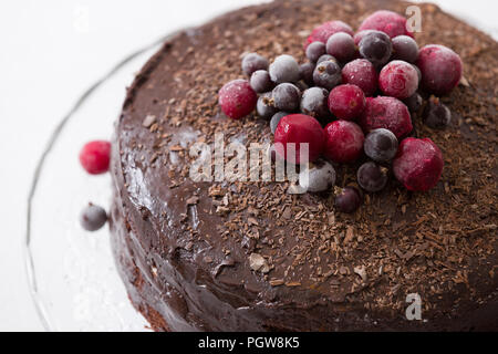 Hausgemachte frische Schokolade Kuchen mit organischen Gefrorene Beeren und Chips auf der Oberseite. Stockfoto