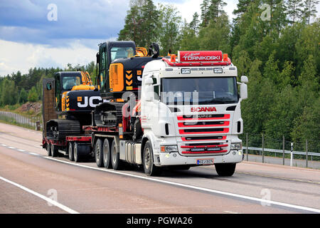 ORIVESI, Finnland - 27. AUGUST 2018: Super Scania Truck von kuljetus Tornikoski Oy Hols zwei neue Mid-size JCB Bagger entlang der Autobahn im Spätsommer. Stockfoto