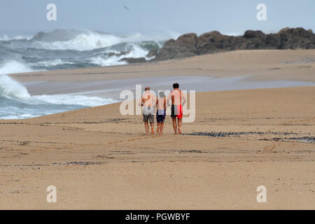 Matosinhos, Portugal - Oktober 19, 2014: Drei männliche Personen, zwei Erwachsene und ein junger Mann, der auf einem einsamen Strand im Norden Portugals Stockfoto