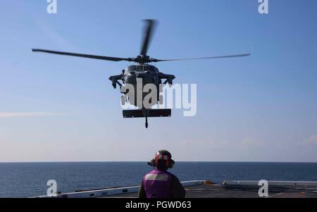 180826-N-HG 389-0025 ATLANTIK (Aug. 26, 2018) Chef der Luftfahrt Bootsmann Mate (Kraftstoff) Koko Shalifoe Uhren einem MH-60S Sea Hawk Hubschrauber der "Ladegeräte" der Hubschrauber Meer Combat Squadron (HSC) 26 Abstieg zum Flight Deck von amphibious Transport dock Schiff USS Arlington LPD (24) Während der Carrier Strike Group (CSG 4) amphibische bereit, Gruppe, Marine Expeditionary Unit Übung (ARGMEUEX). Kearsarge Amphibious Ready Gruppe und 22 Marine Expeditionary Unit sind die Verbesserung der gemeinsamen Integration, die Letalität und kollektiven Fähigkeiten des Navy-Marine Corps Team durch gemeinsame Plan Stockfoto