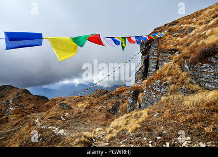 Felsen und tibetischen Gebetsfahnen Lunge Ta am Mardi Himal Base Camp bei bewölktem Gipfeln des Himalaya in Nepal Stockfoto