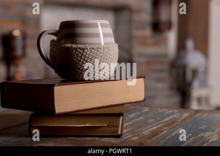 Tasse heißen Kaffee oder Tee, Kakao, Schokolade Schal und Bücher auf Holztisch, getönten Foto. Herbst Konzept Stapel von Büchern, Tasse Kaffee und warmen Schal. süße Momente der Entspannung mit Büchern und einem heissen Getränken. Stockfoto