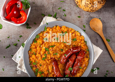 Linsen Eintopf mit gebratenen Würstchen, Zwiebeln und Knoblauch und einige Pickles - Ansicht von oben Stockfoto