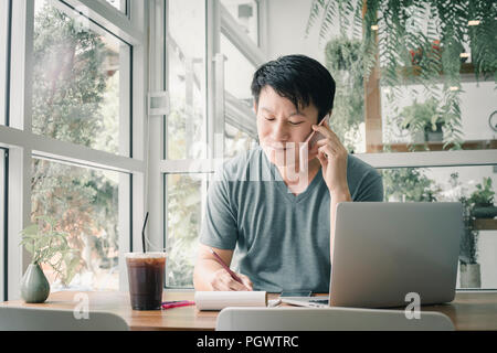 Freelancer Mann online Arbeiten an seinem Haus. Stockfoto