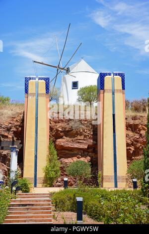 Zier-spalten in Gärten an der Spitze des Hügels mit einem traditionellen Weißen Mühle an der Rückseite, Castro Marim, Algarve, Portugal, Europa. Stockfoto