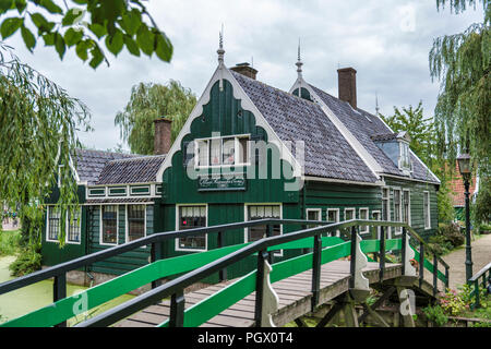 Zaandam, Niederlande, 28-Aug-2018: alten grünen Holzhäuser von wenigen hundert Jahren oldstill Original und immer noch bewohnt, mit einem grünen Brücke über den kleinen Flüssen. Dieses Teil aufgerufen wird zaanmse Schans Stockfoto