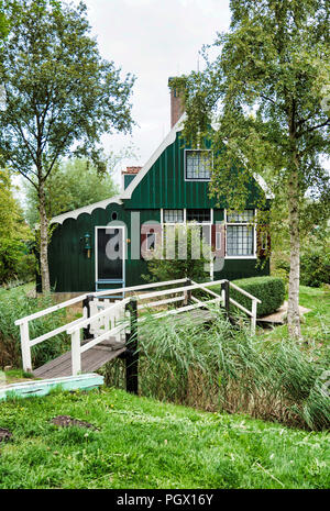 Zaandam, Niederlande, 28-Aug-2018: alten grünen Holzhäuser von wenigen hundert Jahren oldstill Original und immer noch bewohnt, mit einem grünen Brücke über den kleinen Flüssen. Dieses Teil aufgerufen wird zaanmse Schans Stockfoto