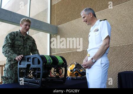 CHATTANOOGA, Tennessee (14. Juni 2018) Navy Diver 2. Klasse Dylan LaFountain, Links, auf Mobile Tauchen Bergung Einheit zwei zugeordnet ist, zeigt der Adm. Paul Pearigen, rechts, Commander, Marine Medizin West, und Chef der Marine Medical Corps, einige der Anlagen auf dem Tennessee Aquarium während Marine Woche Chattanooga. Während der Woche, Marine Taucher nicht nur verbrachte Zeit im Tank der Aquarium, Sie interagiert auch mit der Öffentlichkeit eine praktische Ausbildung über die Ausrüstung, die Sie in Ihrer Arbeit verwenden. Marine Wochen Ziel Gemeinschaften über Amerika mit Marine Programme, Personal und Gerät an Stockfoto