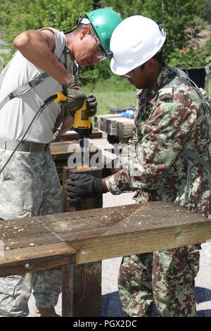 Us-Armee SPC. Fred Grinnell mit den 155 Ingenieur Firma, South Dakota der National Guard, und Suriname Sgt. Vikash Boedhai mit der Maitenance Unternehmen von Suriname Suriname Streitkräfte, bohrt Löcher in eine Verstrebung während einer Brücke reparieren Projekt zur Unterstützung von Golden Coyote, Totholz, S.D., 15. Juni 2018. Die goldenen Coyote Übung ist eine dreiphasige, Szenario-driven Übung in den Black Hills von South Dakota und Wyoming, mit dem Kommandanten auf der Mission wesentliche Anforderungen der Aufgabe, Krieger Aufgaben und Übungen zu konzentrieren. Stockfoto