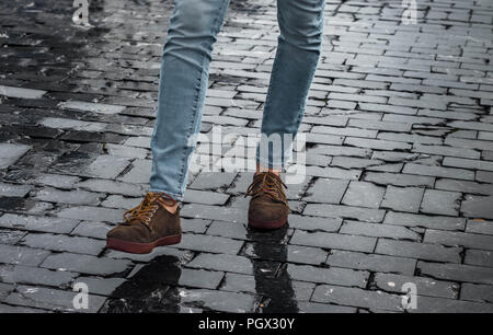 Mann braun hipster Schuhe und Beine an der Straße mit schwarzen Steinen einen Schritt Stockfoto
