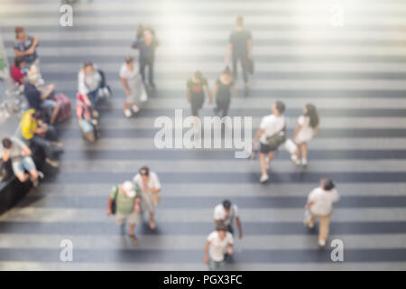 Abstrakte verschwommen wandern Menschen in Flughafen oder Bahnhof Bereich mit gestreifter Boden. Sommer Zeit, Ansicht von oben. Stockfoto