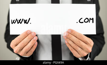 Nahaufnahme der männlichen Händen hält Weißbuch mit www.com auf ihn mit leeren Raum bereit für Ihren Text, Website oder Domain geschrieben. Stockfoto