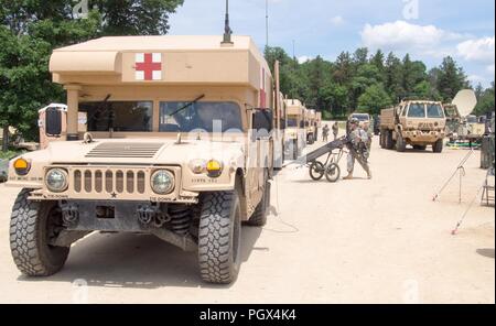 Krankenwagen kommen als US Army Reserve Soldaten mit 865Th Combat Support Hospital in Utica, New York, sind Offloading simulierten verletzte Soldaten und die Durchführung der Triage als Teil einer Masse Unfallversicherung Übung während der Regionalen Medic CSTX 86-18-04, taktische Schulung Base Gerechtigkeit auf Fort McCoy, Wisc., 23. Juni 2018. CSTX 86-18-04 ist ein Kampf Support Training übung, die sicherstellt, dass America's Army Reserve Einheiten und Soldaten ausgebildet sind und bereit, auf kurze bereitstellen - Bekanntmachung und fähig, Bekämpfung bereit, und tödlichen Feuerkraft zur Unterstützung der Armee und unsere gemeinsamen Partner überall in der Welt. Us-Arm Stockfoto