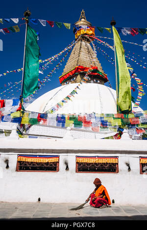 Bodhnath, Katmandu, Bagmati, Nepal: Ein buddhistischer Mönch in braunen Roben Sweep der Boden um die große Stupa von Bodhnath, das größte in Asien und eine Stockfoto