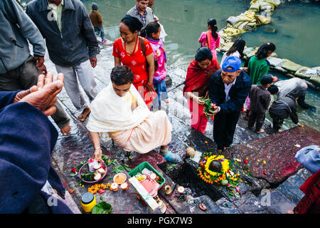 Pashupatinath Tempel, Kathmandu Tal, Bagmati, Nepal, Südafrika Asien: ein Priester den Gläubigen die religiöse Angebote im Shiva Lingam auf t teilnehmen Stockfoto