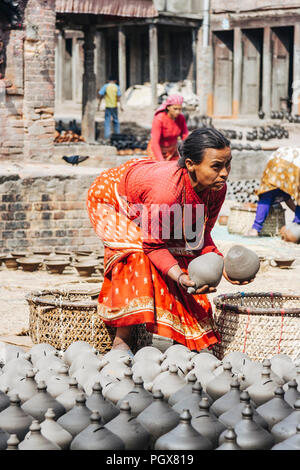Bhaktapur, Tal von Kathmandu, Nepal Bagmati: Frau an der Arbeit an Potters' Square (Bolachha Tole) im Unesco Weltkulturerbe Altstadt von Bhaktapur. Stockfoto