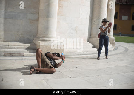 Piazza dei Miracoli. Wunder qm Touristen posieren und mit Leanin Turm spielen Stockfoto