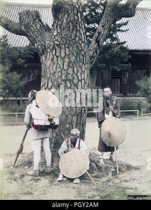 [1880s Japan - buddhistische Pilger ruhen auf Tempel] - Drei Pilger sind ruhen auf einem Verwitterten Kiefer in, was scheint, die Begründung eines buddhistischen Tempel. Sie tragen weiße Gewänder, sugegasa (segge - gewebt Hüte) und waraji (Stroh Sandalen). Sie sind auch mit langen Stöcken und primitiven Rucksäcke tragen. Sie sind auf einer Pilgerfahrt nach Kotohira-gu Schrein, besser als konpira-san, in der Präfektur Kagawa bekannt. 19 Vintage albumen Foto. Stockfoto