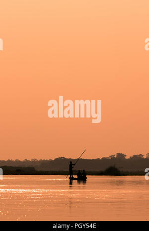 Mann in einem Boot auf einem Fluss Silhouette mit Sonnenuntergang Licht Stockfoto