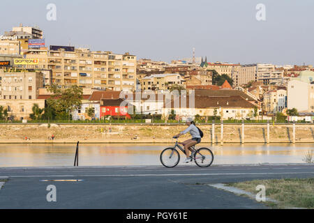 Frau Radfahren entlang dem Radweg an der Sava am Flussufer mit Blick auf die Altstadt von Belgrad, Serbien. Stockfoto