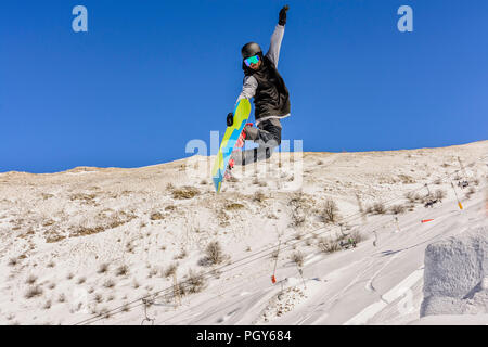 Eine freestyle Snowboarder macht einen rückwärtig Luft schnappen Stockfoto