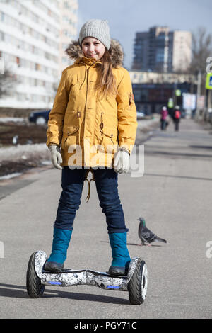 Glückliche junge Kaukasische Mädchen fahren selbst ausgeglichen Fahrzeug auf der Straße Bahn Stockfoto