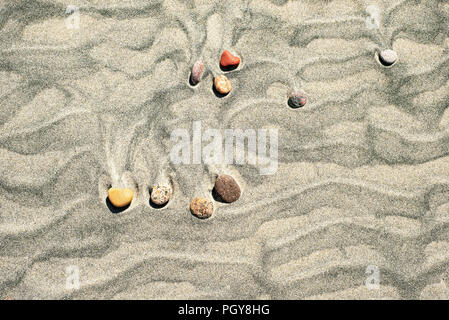 Wellen und Steine im Sand am Strand. Ansicht von oben. Stockfoto