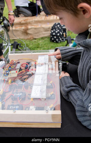 Newport, Wales - 23 Aug 14: Junge untersucht Velogenerator Platine des Pedal powered Friseur am 14. August 2015 an die Grüne Sammeln Stockfoto