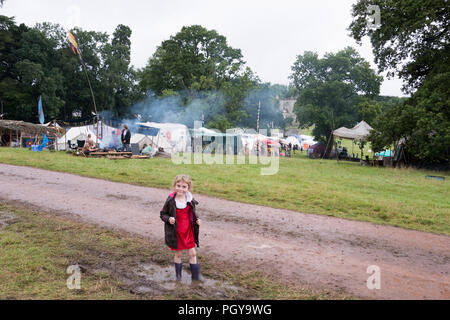 Newport, Wales - 23 Aug 14: Ein junges Mädchen, das gerne spielt in einer schlammigen Pfütze neben der Spur auf einer an den Grünen sammeln Festival 14 Aug 2015 wet Stockfoto