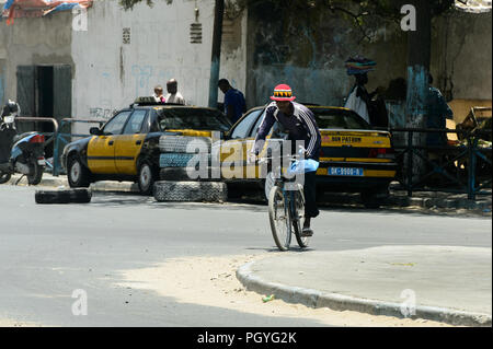 DAKAR, SENEGAL - 23.April 2017: Unbekannter senegalesischen Mann reitet ein Fahrrad in Dakar, der Hauptstadt Senegals Stockfoto