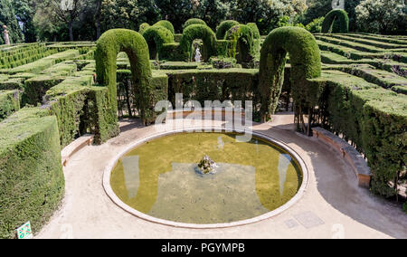 Kleinen kreisförmigen Teich an der Ausfahrt des Labyrinth Labyrinth Park von Horta. Die zentrale Statue von Eros und Zypresse Bögen sind im Hintergrund sichtbar. Stockfoto