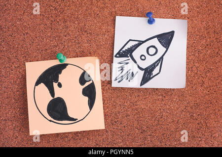 Post-it Notes mit dem Planeten Erde und Weltraum Rakete auf Bulletin Board. Close Up. Stockfoto