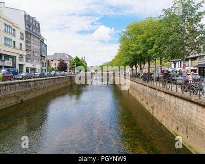 Quimper, Frankreich - 8 August 2018: mit Blick auf die Odet Fluss durch Quimper zwischen Baum fließende gesäumt von Banken, die von gewerblichen Gebäuden und Pa begrenzt Stockfoto